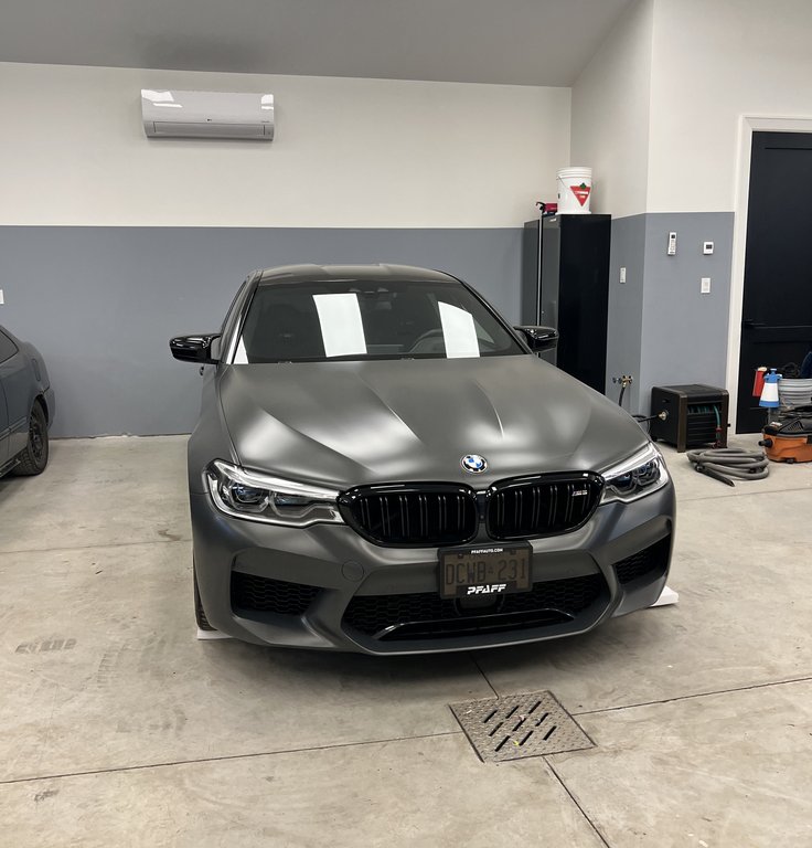 BMW M5 sports sedan undergoing premium auto detailing and ceramic coating