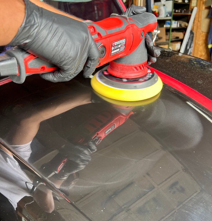 Vehicle paint surface after ceramic coating treatment showing hydrophobic water beading effect